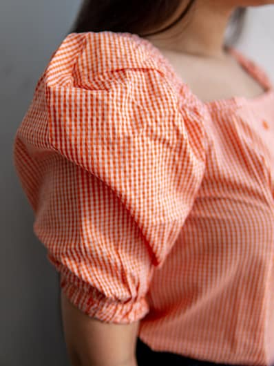 Orange Checkered Square Neck Puff Short Sleeve Top by Gorur Ghash. Fabric: Cotton. Price: ৳1000. Made in Bangladesh (BD). Buy the tops now!